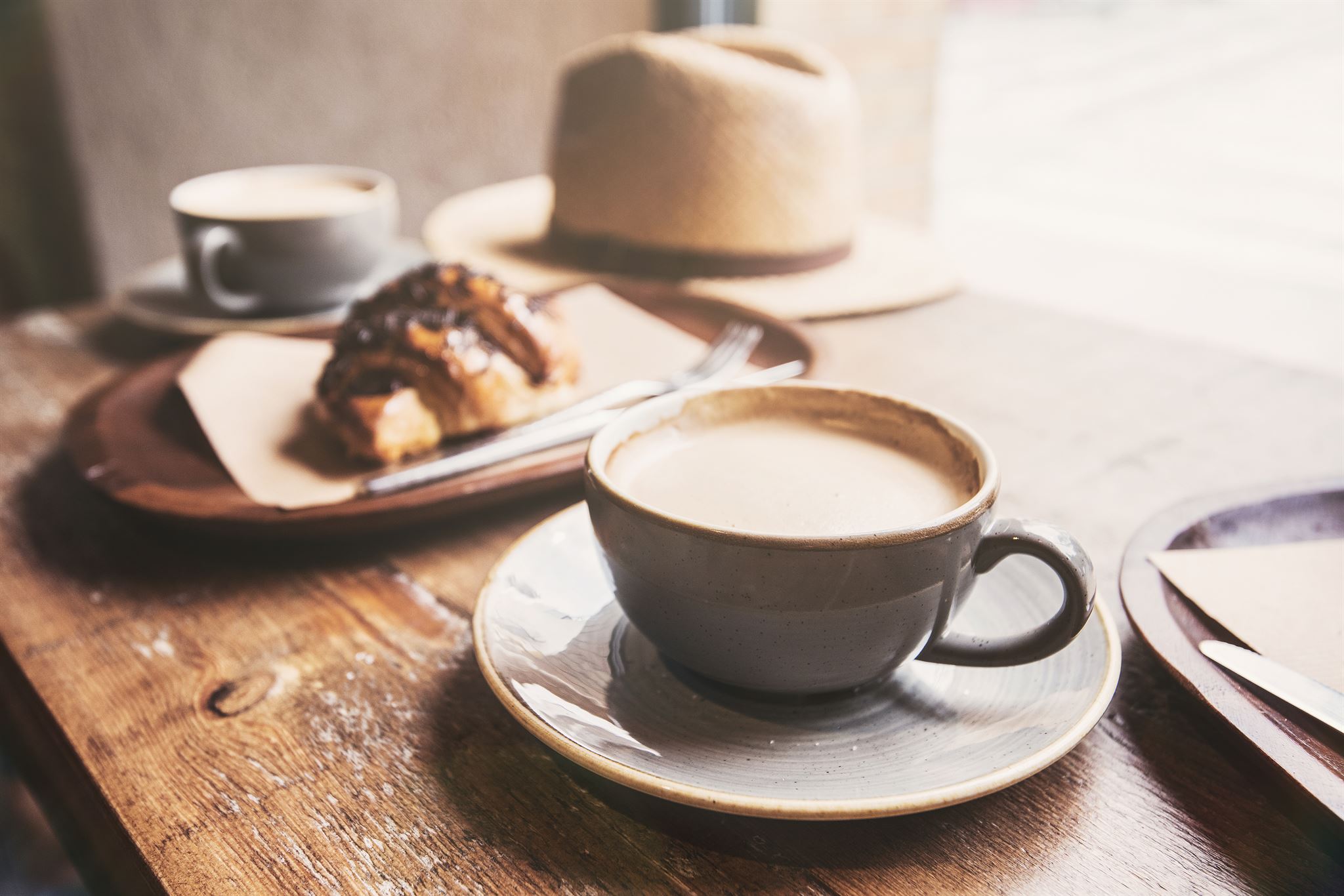 Assortment of coffee drinks and pastries on wooden counter