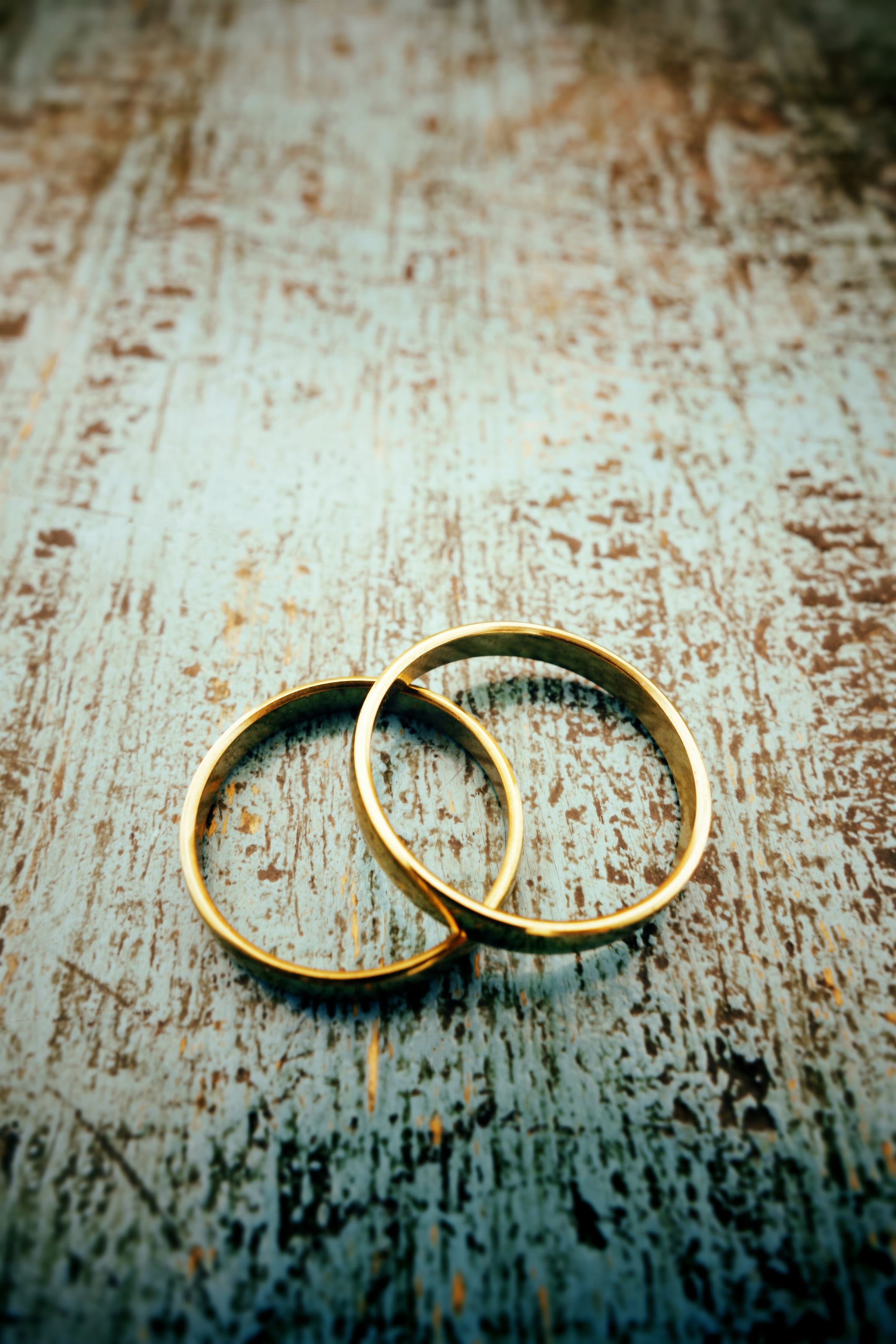 Wedding rings on rustic wood surface