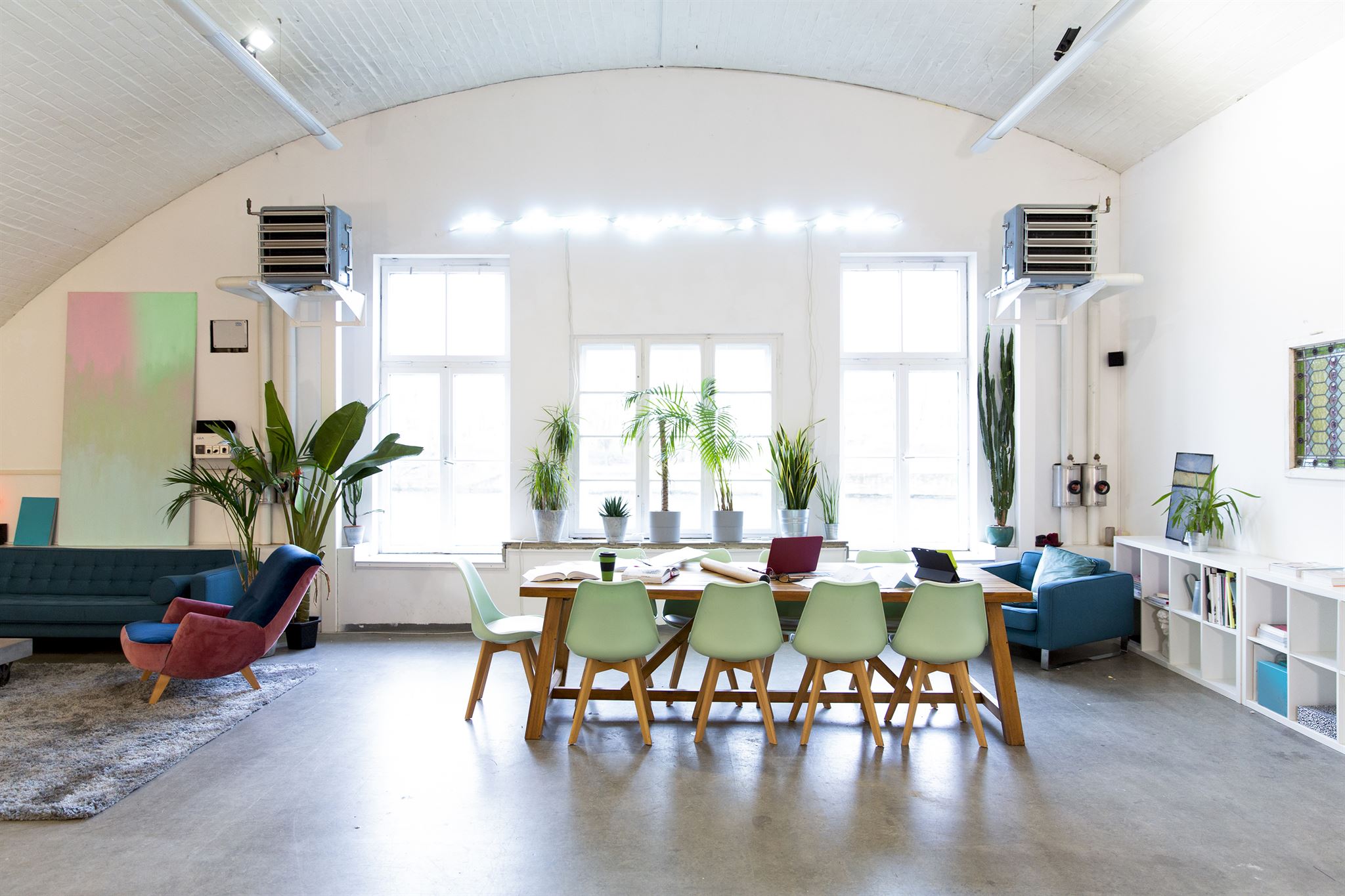 Industrial loft cafe seating area with exposed pipes and wooden tables