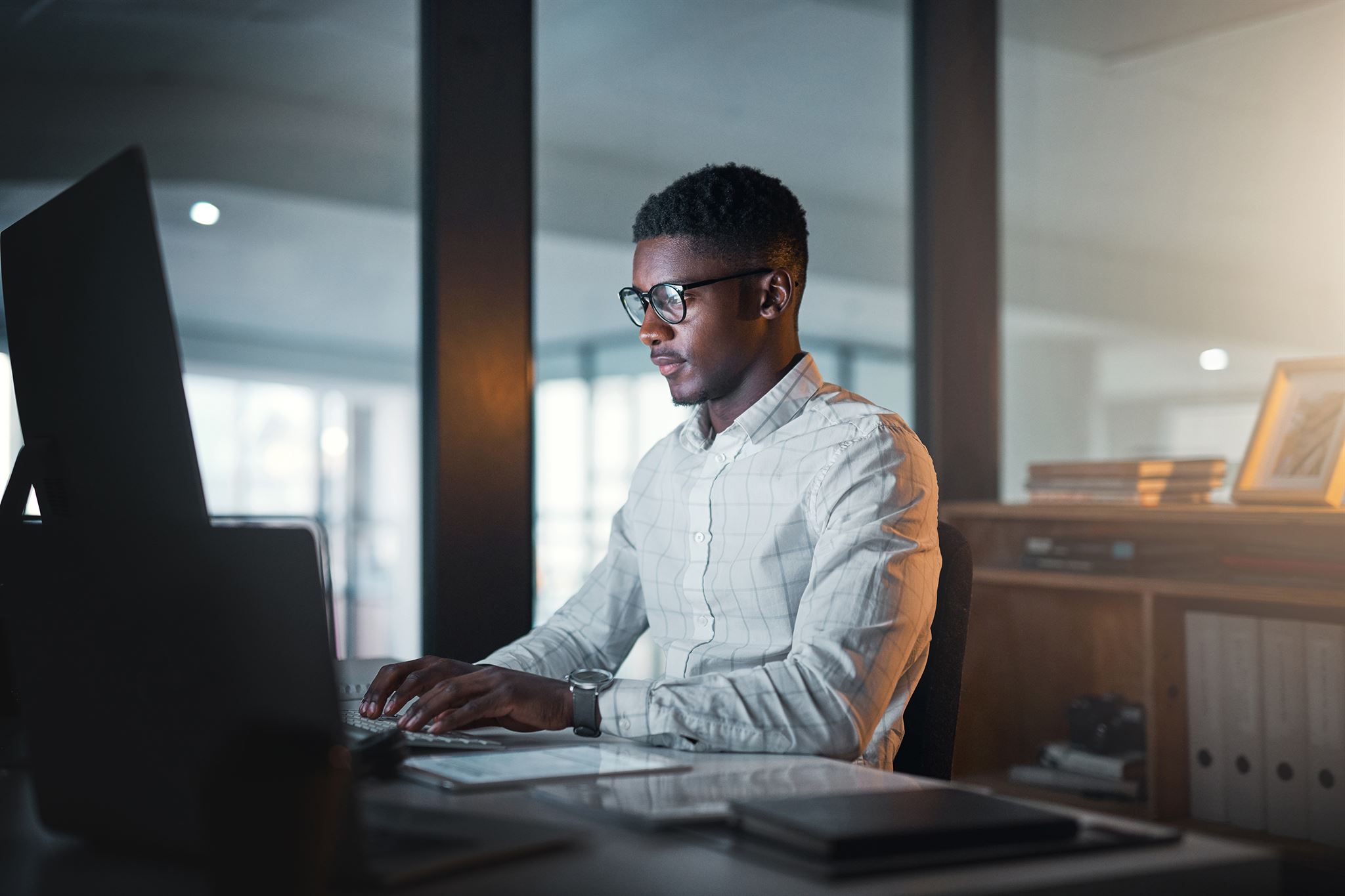 IT professional working on laptop with network diagrams