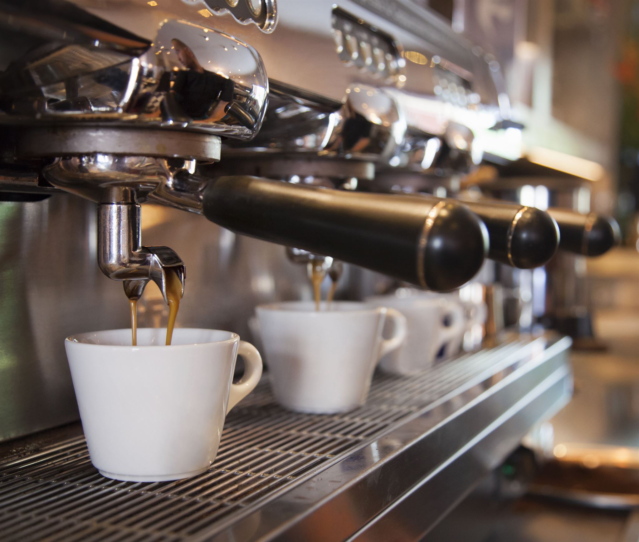 Barista preparing coffee with industrial espresso machine