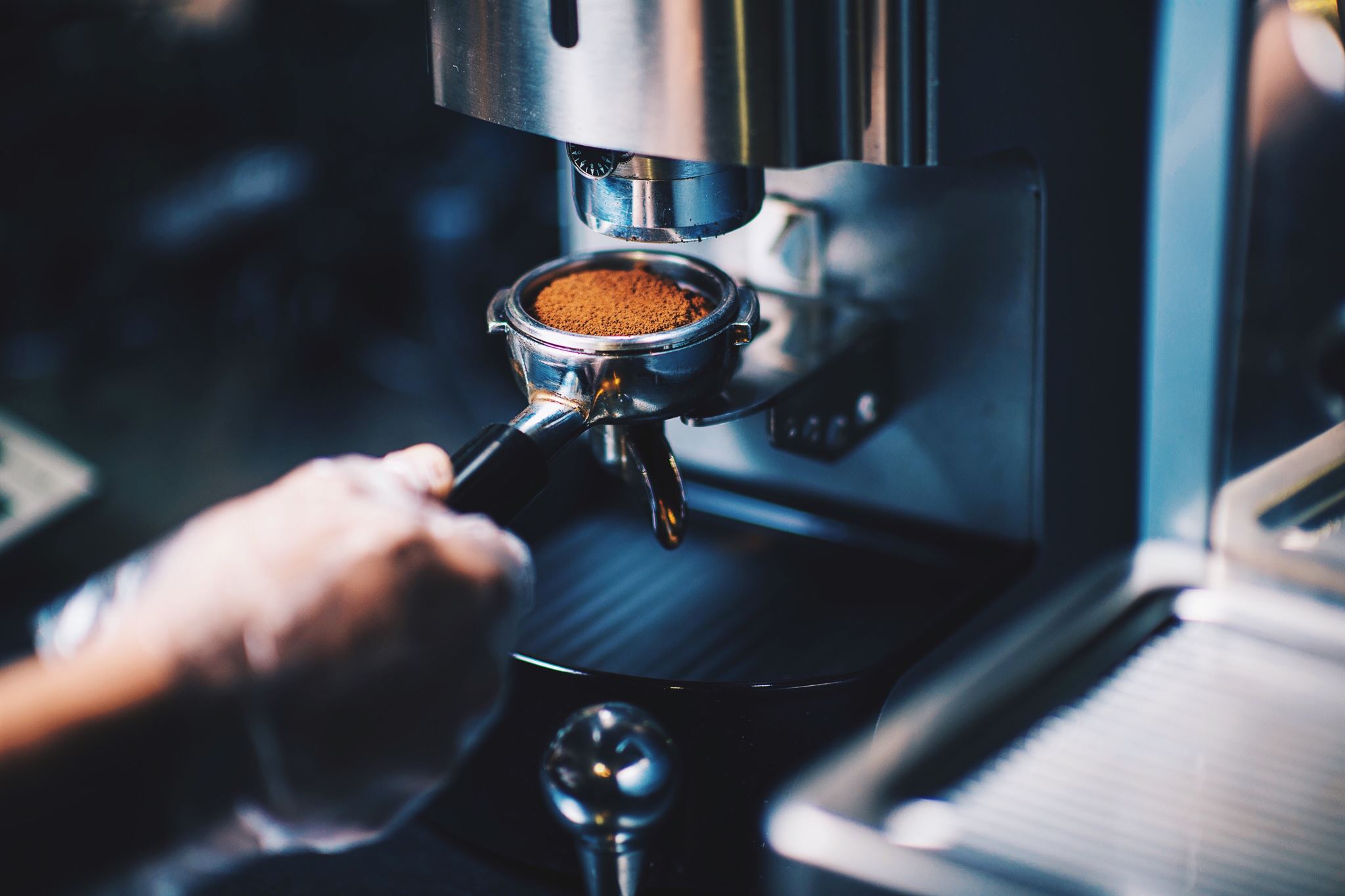 Barista preparing coffee using manual coffee machine
