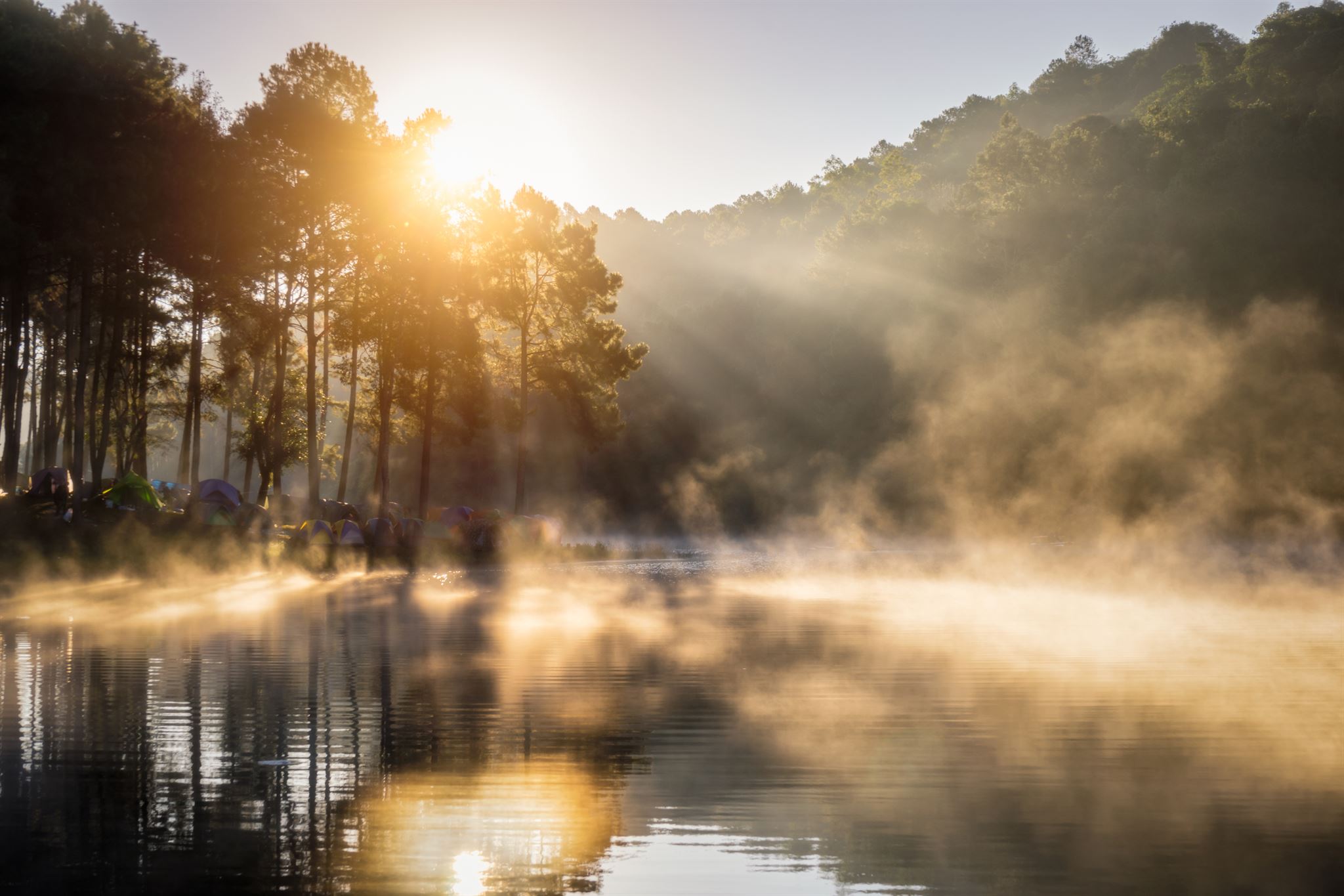 Serene lake at sunrise with calm water and soft light